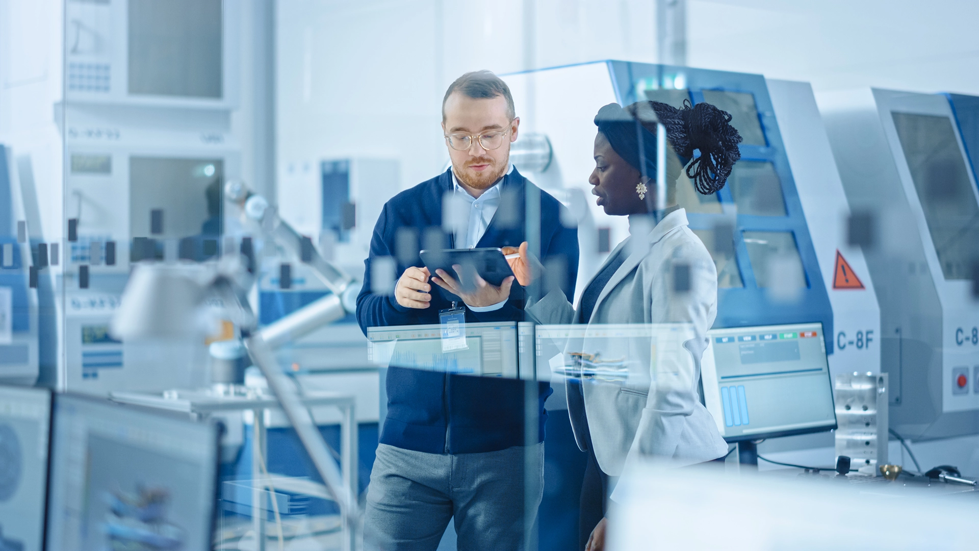 Manufacturing engineers reviewing project plans inside a modern industrial facility