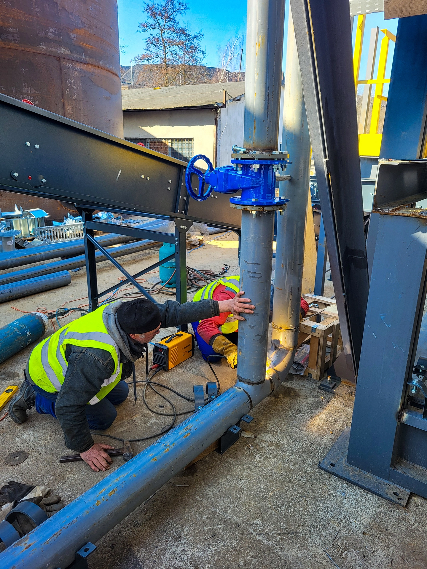 Mechanical trades working together on industrial pipe installation